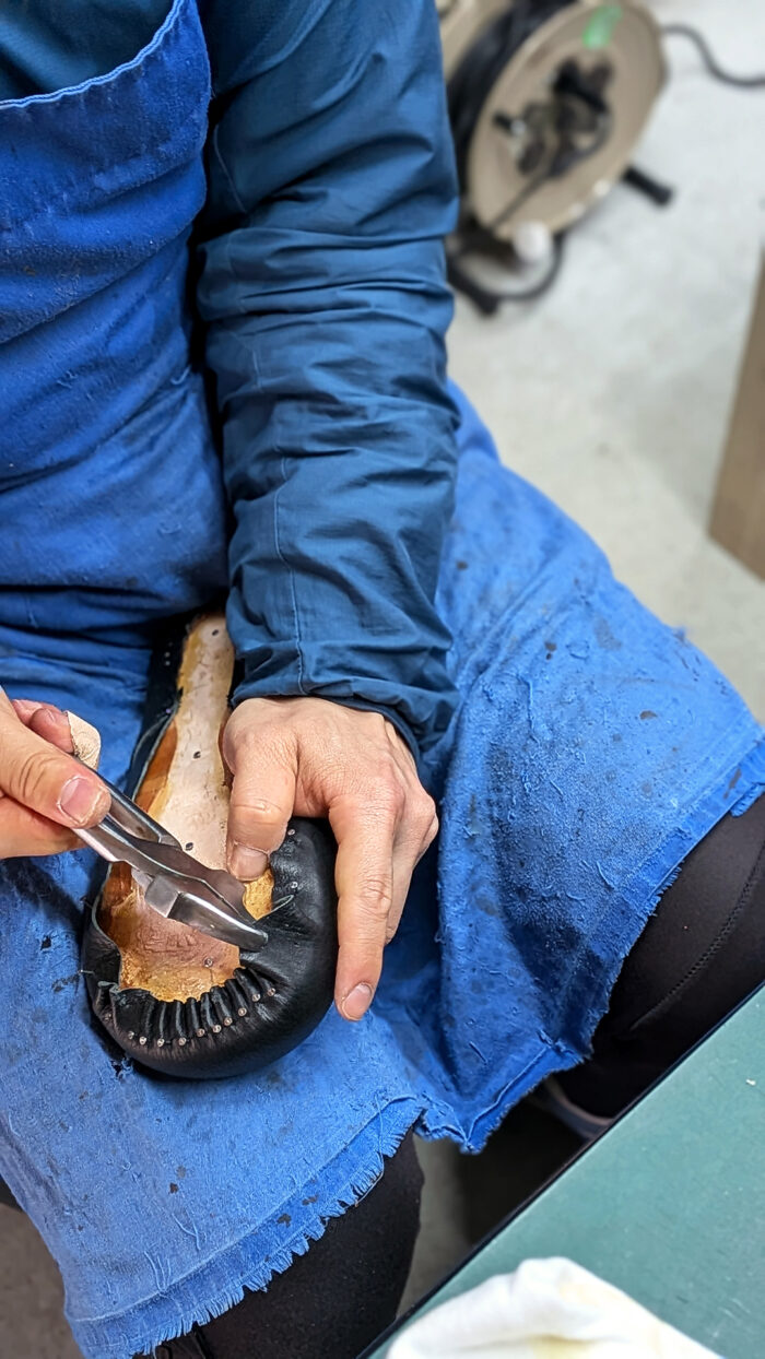 木型にアッパーを引き込むつりこみ作業（チャッカブーツ製作）